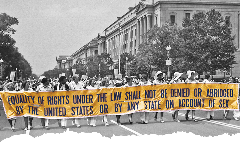 Image of marchers carrying a banner that reads: Equality of Rights Under the Law Shall Not Be Denied or Abridged by the United States or by Any State on Account of Sex
